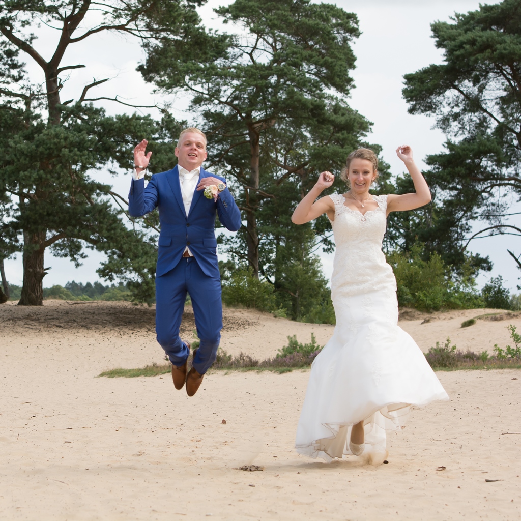 bruidspaar-springen-in-het-zand